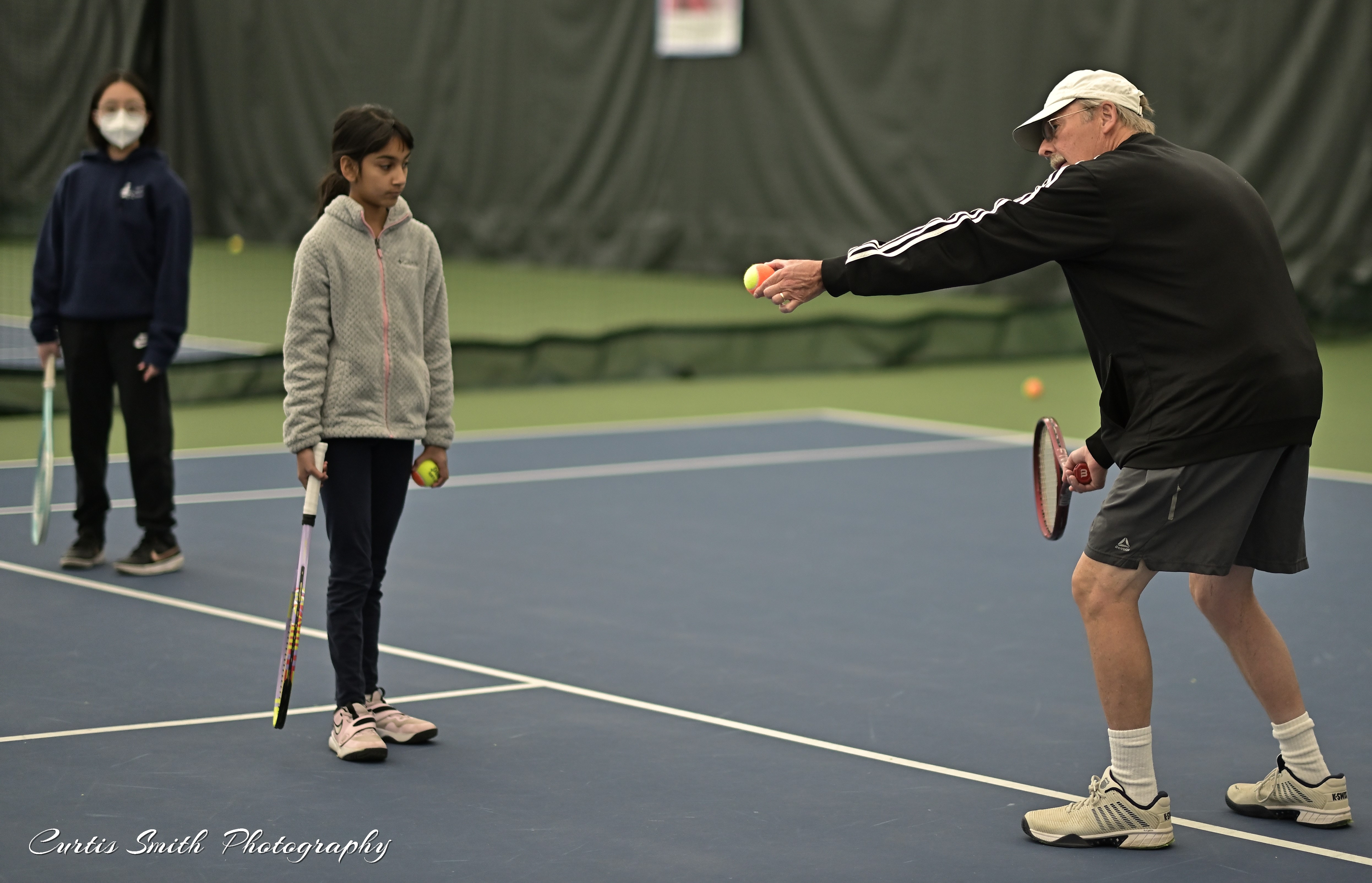 Brian Loomis teaching tennis skills in a class